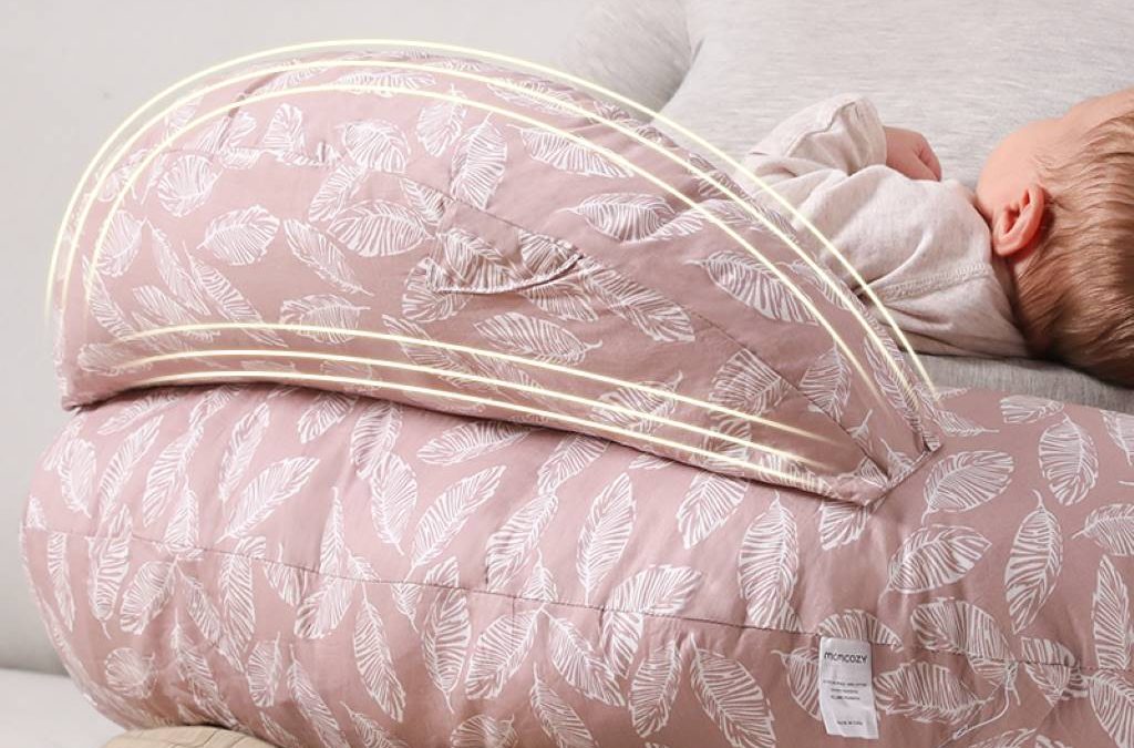 New mom smiling while breastfeeding comfortably with Momcozy Original nursing pillow around waist