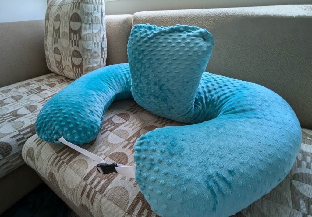 Twin babies feeding peacefully side by side on wide Momcozy nursing pillow surface