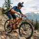 Cyclist testing a mountain bike on a rocky trail to evaluate braking and gear shifting performance before purchase