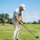 Golfer wearing a moisture-wicking cap on a sunny golf course during a summer round