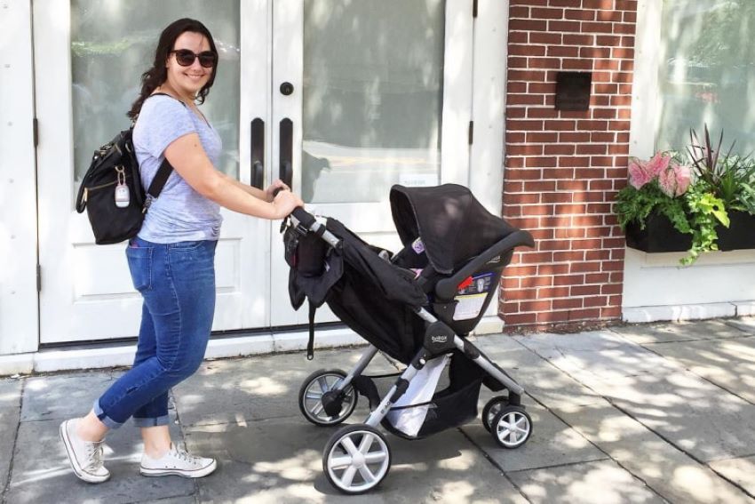 Parent using a compact baby stroller on public transportation