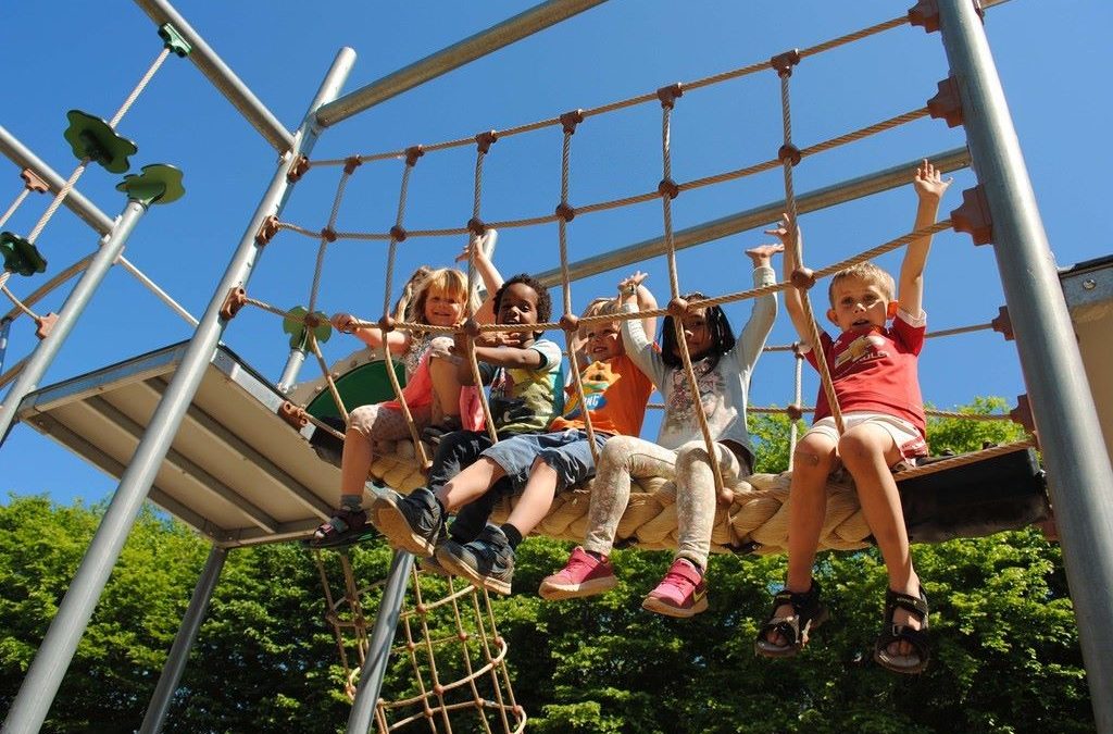 Child climbing rope ladder in a home backyard play set