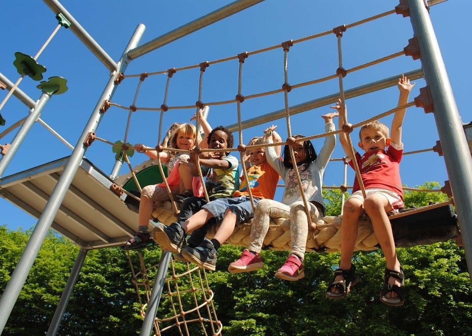 Child climbing rope ladder in a home backyard play set