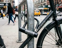 A heavy-duty U-lock securing a bicycle to a city bike rack.