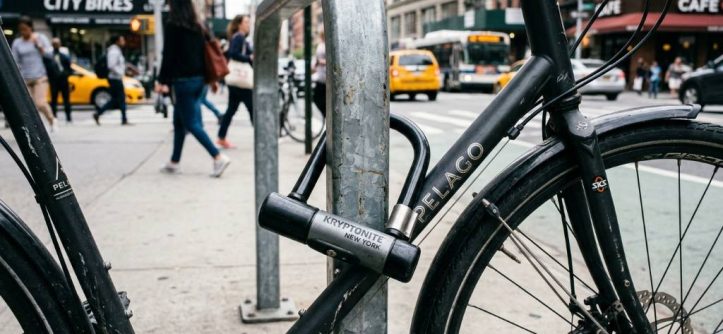 A heavy-duty U-lock securing a bicycle to a city bike rack.
