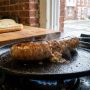 Whole golden Italian sausages cooking gently in skillet water
